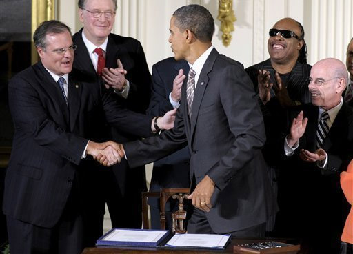 President Obama shakes hands with people at after signing communications and video accessibility act.