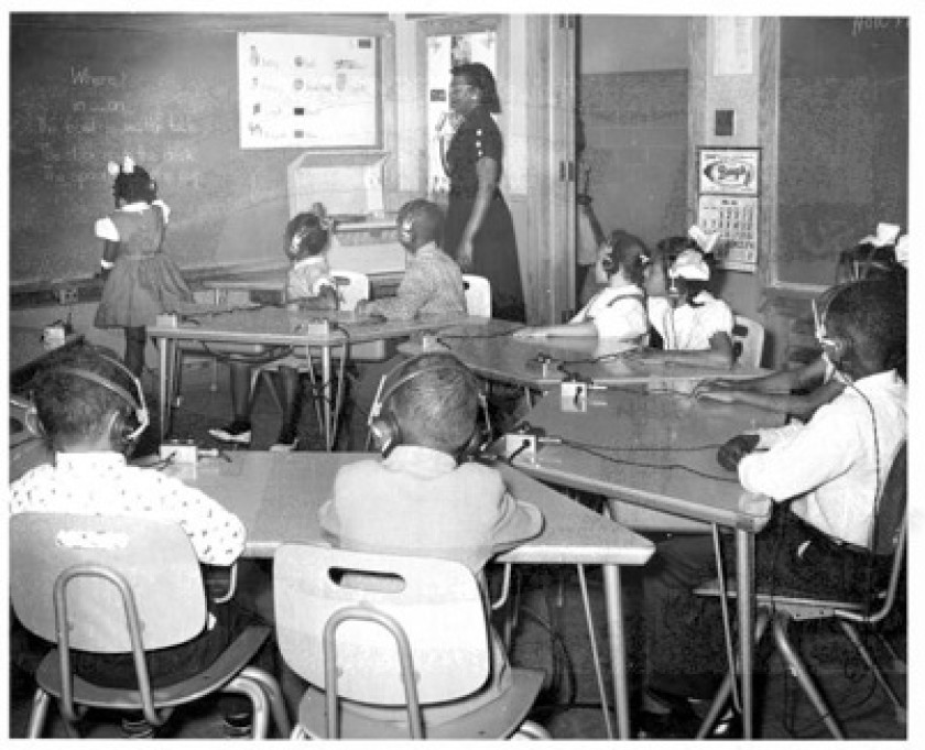 Vintage photo of Louisiana State School for the Colored Deaf and Blind classroom with several black students and a teacher.