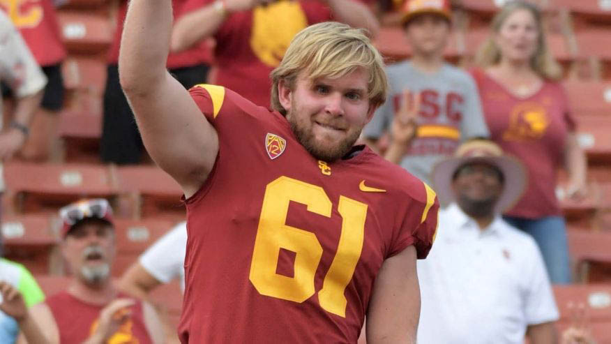 Jake Olson smiling and wearing a football uniform on the field.